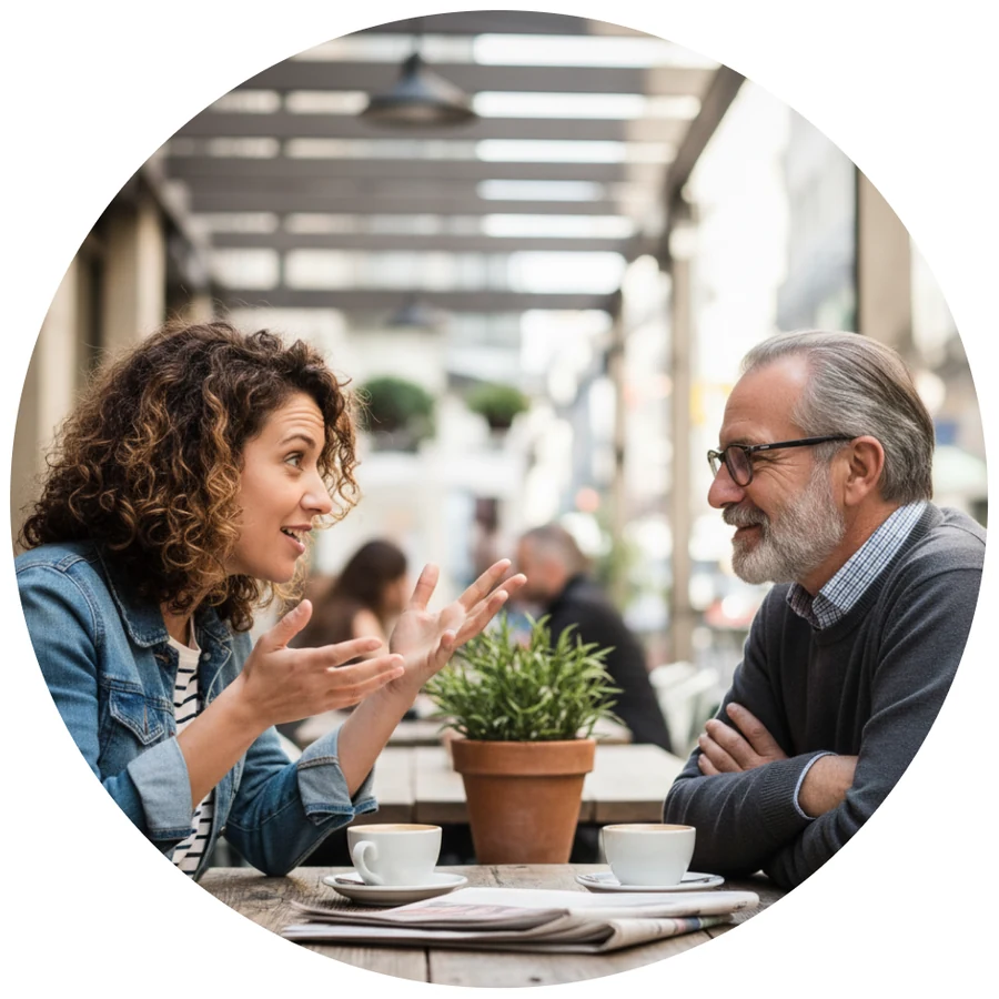 A man and a woman talking over coffee at an outdoor cafe table.