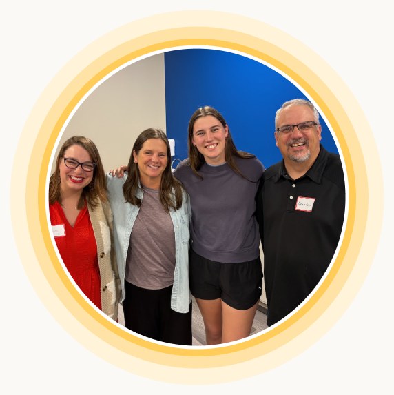 Four Multipli participants standing together and smiling at a training event.